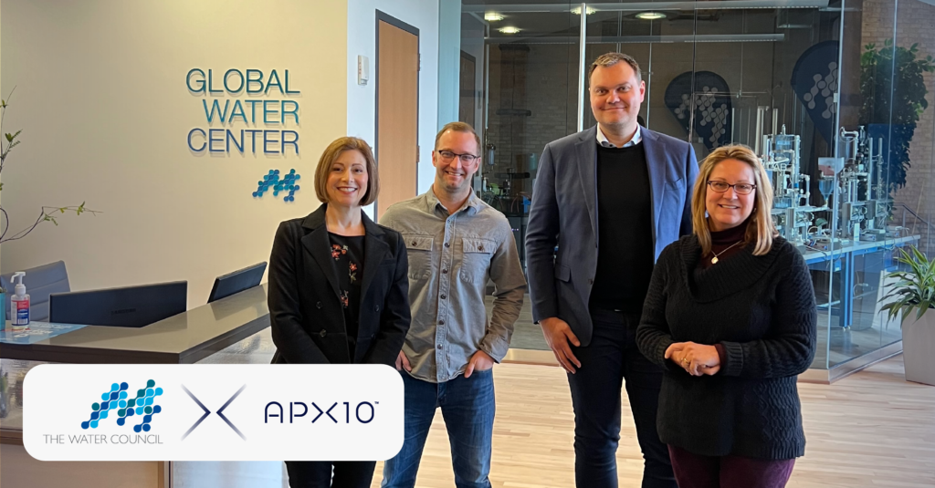 Two women and two men stand in a lobby with the words "Global Water Center" on the wall behind them.