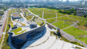 Industrial building with a green roof surrounded by green parkland.