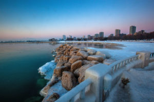 Picture of a snowy walk along Lake Michigan at sunrise with Milwaukee skyline in the background