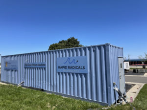A blue large containment unit set in the grass