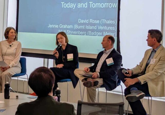 people speaking on stage at a conference
