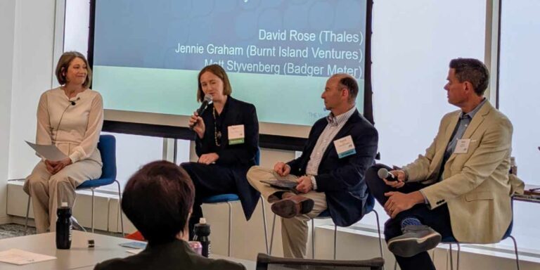 people speaking on stage at a conference