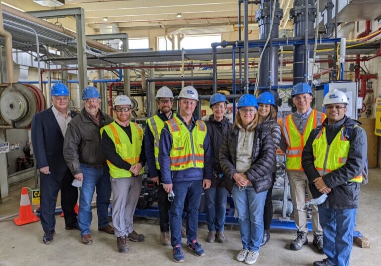 Group of people in hard hats standing in warehouse