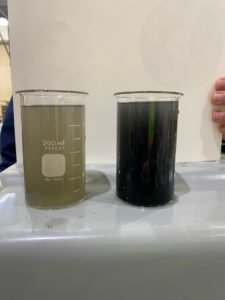 Two beekers, one with light gray water and one with dark gray water